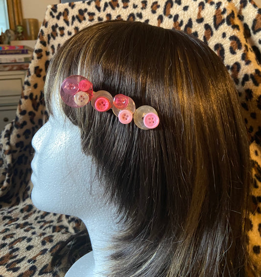 Barrette à boutons blanc et rose.